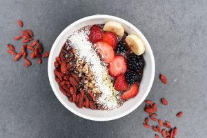 bol petit déjeuner healthy avec baies de goji noix de coco râpée et fruits